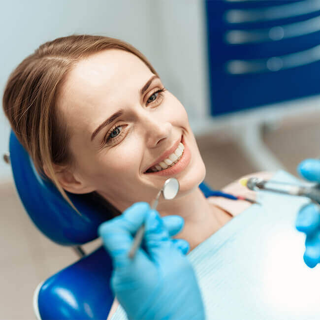 Patiente souriante pendant un soin esthétique dentaire